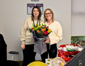 Rebecca, CEO, presenting Amy with flowers